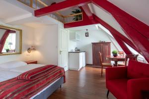 1 dormitorio con 1 cama, 1 silla roja y 1 mesa en Amsterdam House Hotel, en Ámsterdam