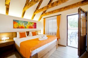 1 dormitorio con 1 cama grande con sábanas de color naranja en (Ne)vinná kavárna, en Mikulov