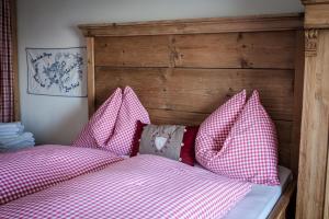 uma cama com almofadas cor-de-rosa e brancas em Angerer Alm em Sankt Johann in Tirol