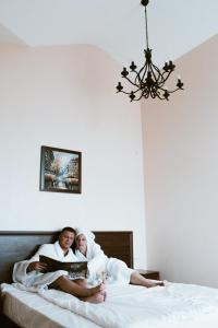 un hombre y una mujer acostados en una cama leyendo un libro en Mаgellan House, en Bor