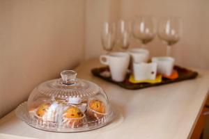 einer Theke mit Muffins in einem Glasbehälter auf einem Tisch in der Unterkunft Sweet Rooms Cagliari in Cagliari