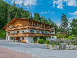 a building in the mountains with a fence at Pension Pichler in Leutasch