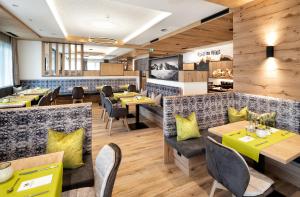 a dining room with tables and yellow pillows at Hotel Modern Mountain in Ischgl