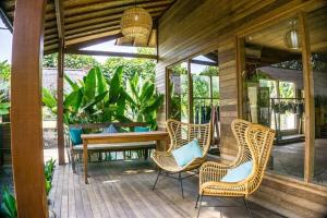 porche con sillas de mimbre y mesa de madera en Green Garden Lembongan Yoga Spa and Holistic Healing Center, en Nusa Lembongan