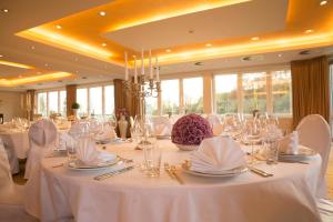 ein Esszimmer mit weißen Tischen und weißen Stühlen in der Unterkunft l'Arrivée Hotel & Spa in Dortmund + 124 Fotos