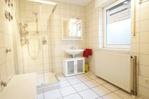 uma casa de banho branca com um lavatório e um chuveiro em Ferienwohnung Behner em Greven