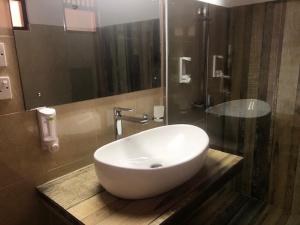 a bathroom with a white sink and a mirror at Ypsylon Tourist Resort in Beruwala