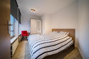 a bedroom with a large bed and a red chair at 21 Allée Scheffer in Luxembourg