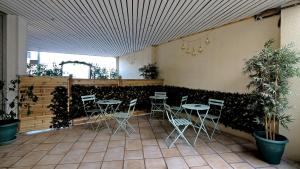 维勒班特Le Vert Galant Villepinte Gare Vert Galant Parc des Expositions的有桌椅和植物的餐厅