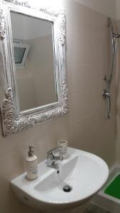 y baño con lavabo blanco y espejo. en Almasol, en Cassano delle Murge