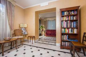 a living room with a book shelf filled with books at Hotel Arco Di Travertino in Rome