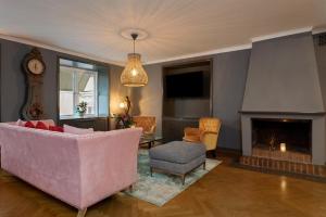 a living room with a pink couch and a fireplace at Victory Apartments in Stockholm