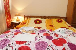 a bed with a colorful quilt and towels on it at Guest House Olga in Budva