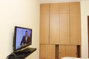 a flat screen tv sitting on a wall next to wooden cabinets at Guest House Olga in Budva