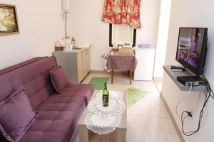 a living room with a purple couch and a table at Guest House Olga in Budva