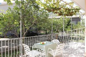 Guest House Olga في بودفا: طاولة وكراسي على شرفة عليها فاكهة