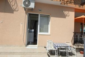 a patio with a table and chairs next to a building at Guest House Olga in Budva