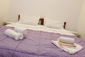 a purple bed with towels and pillows on it at Guest House Olga in Budva