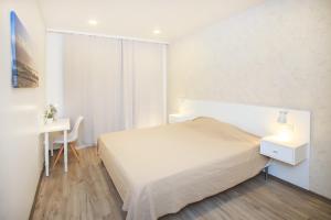 スヴェトロゴルスクにあるKöenig Style 7の白いベッドルーム(ベッド1台、デスク付)
