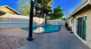 a swimming pool in a yard next to a house at 11640 Gothic Avenue in Los Angeles