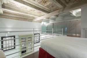 a bedroom with a white bed and a wooden ceiling at Servi Suite in Florence