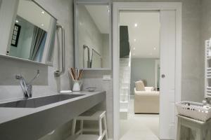 ein Bad mit einem Waschbecken und einem Spiegel in der Unterkunft Servi Suite in Florenz