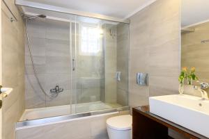 a bathroom with a shower and a toilet and a sink at Bellevue Suites in Agios Nikolaos