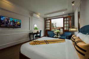 a hotel room with a large bed and a desk at S Central Hotel and Spa in Hanoi