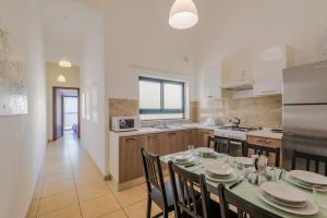 a kitchen and dining room with a table and chairs at Blue Harbour Seafront 3 bedroom apartment, with spectacular sea views from terrace - by Getawaysmalta in St. Paul's Bay