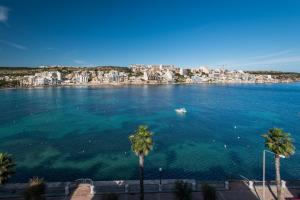 a view of a large body of water with palm trees at Blue Harbour Seafront 3 bedroom apartment, with spectacular sea views from terrace - by Getawaysmalta in St. Paul's Bay