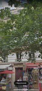 a building with a tree in front of a store at RESIDENCE LANCASTER in Paris