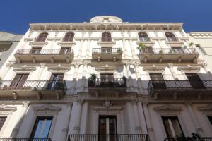 a tall white building with balconies and a blue sky at Dimora Acanto in Bari