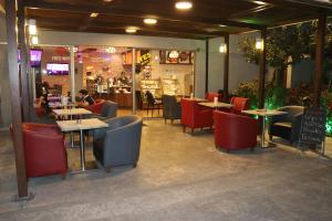 restauracja ze stołami i krzesłami oraz ludzie siedzący przy stołach w obiekcie VU'Z Hotel w mieście Dżubajl