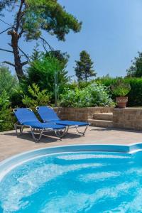 a blue lounge chair next to a swimming pool at Villa Helios in Pefkochori