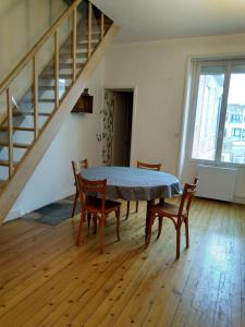 a table and chairs in a room with a staircase at Appartement au calme Centre Ville à 2 pas du vieux marché in La Rochelle