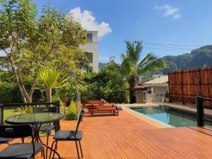 a deck with a table and chairs next to a pool at Siya Private Pool Villa Ao Nang in Ao Nang Beach