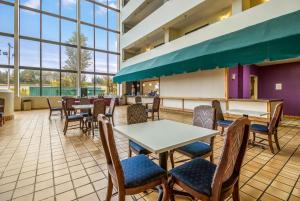 a restaurant with tables and chairs and windows at Clarion Hotel Jackson Northwest in Jackson