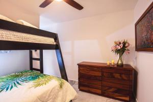a bedroom with a bunk bed and a dresser with flowers at Departamento Aria Ocean in Nuevo Vallarta