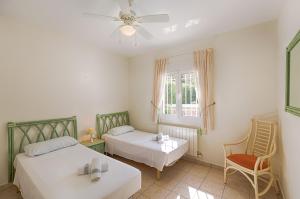 ベニッサにあるVillas Guzman - Olivosのベッドルーム1室(ベッド2台、椅子、窓付)
