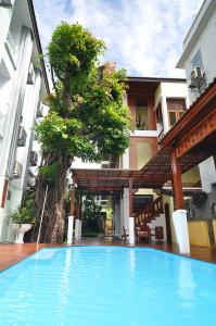 a swimming pool in front of a building at Sripat Guesthouse SHA Extra Plus in Chiang Mai