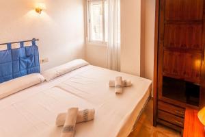a bedroom with a bed with two towels on it at Villas Guzman - Apartamento Murillo in Benitachell