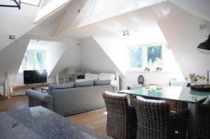 - un salon avec un canapé et une table dans l'établissement Loft aan Zee, Penthouse B&B aan de Schoorlse duinen, à Schoorl