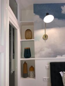 a room with shelves with vases and a lamp at RESIDENCE MONTORGUEIL in Paris