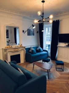 a living room with blue couches and a fireplace at RESIDENCE MONTORGUEIL in Paris