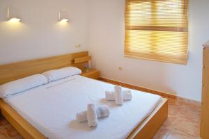 a bedroom with a white bed with towels on it at Villas Guzman - Apartamento Velazquez in Benitachell
