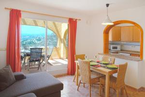 a living room with a table and a kitchen with a view at Villas Guzman - Apartamento Velazquez in Benitachell