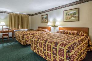 a hotel room with two beds and a table at Rodeway Inn in Bedford +19 photos