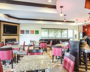 a restaurant with tables and chairs and a fireplace at Comfort Suites Rock Hill Manchester Meadows Area in Rock Hill