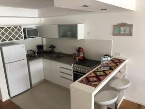 a small kitchen with white cabinets and a counter top at Depto Altos Juramento in Salta