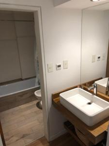 a bathroom with a white sink and a toilet at Depto Altos Juramento in Salta +25 photos
